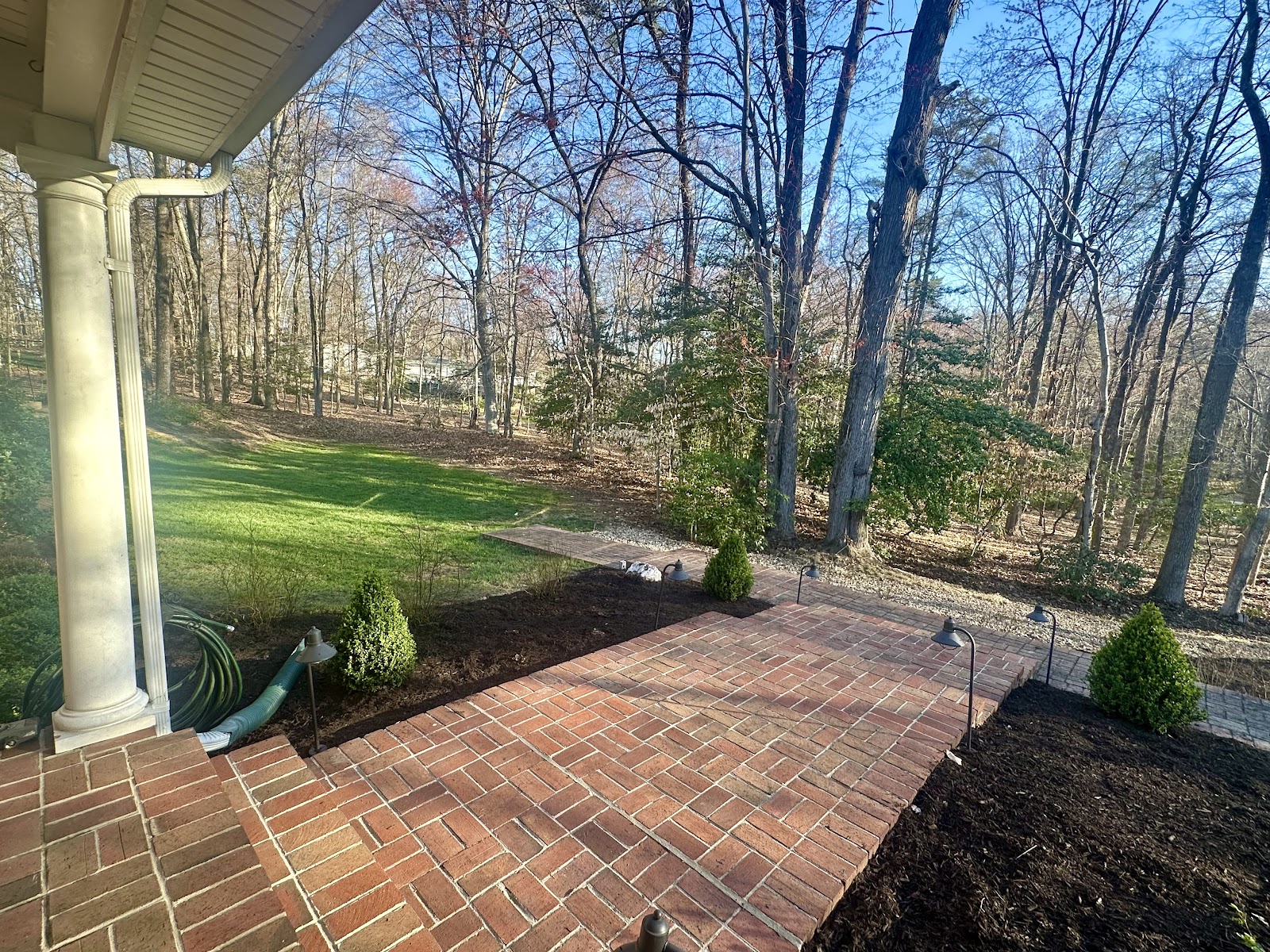 Brick paver patio beside a covered porch